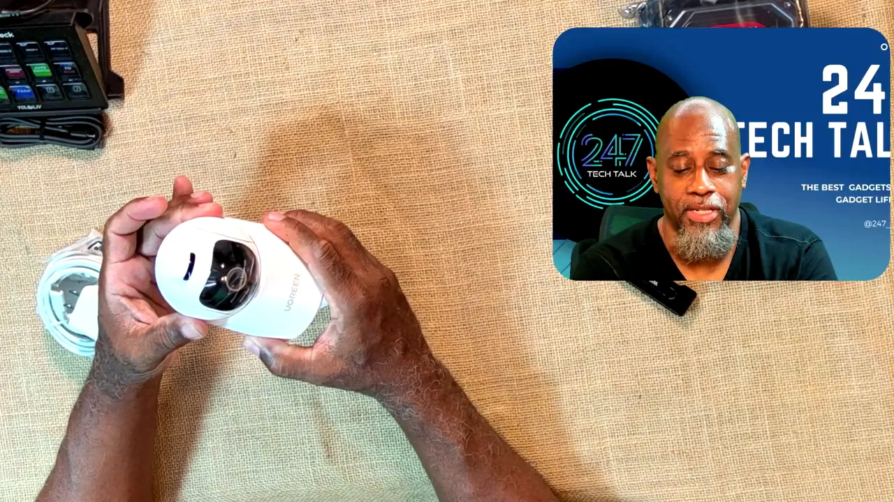 White indoor camera held horizontally with its black lens housing and underside visible