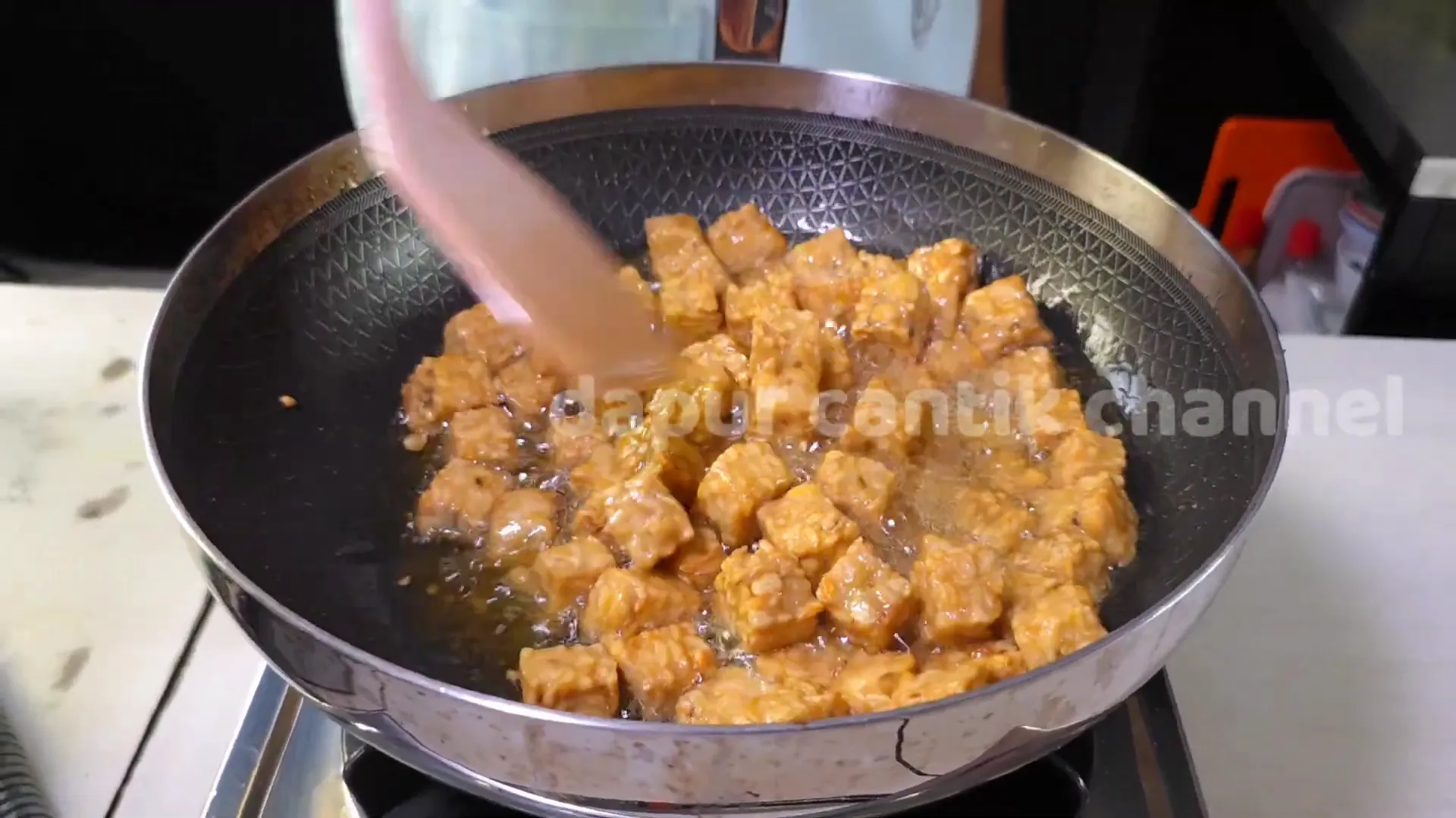 Tempe digoreng hingga kecoklatan sebelum dimasak