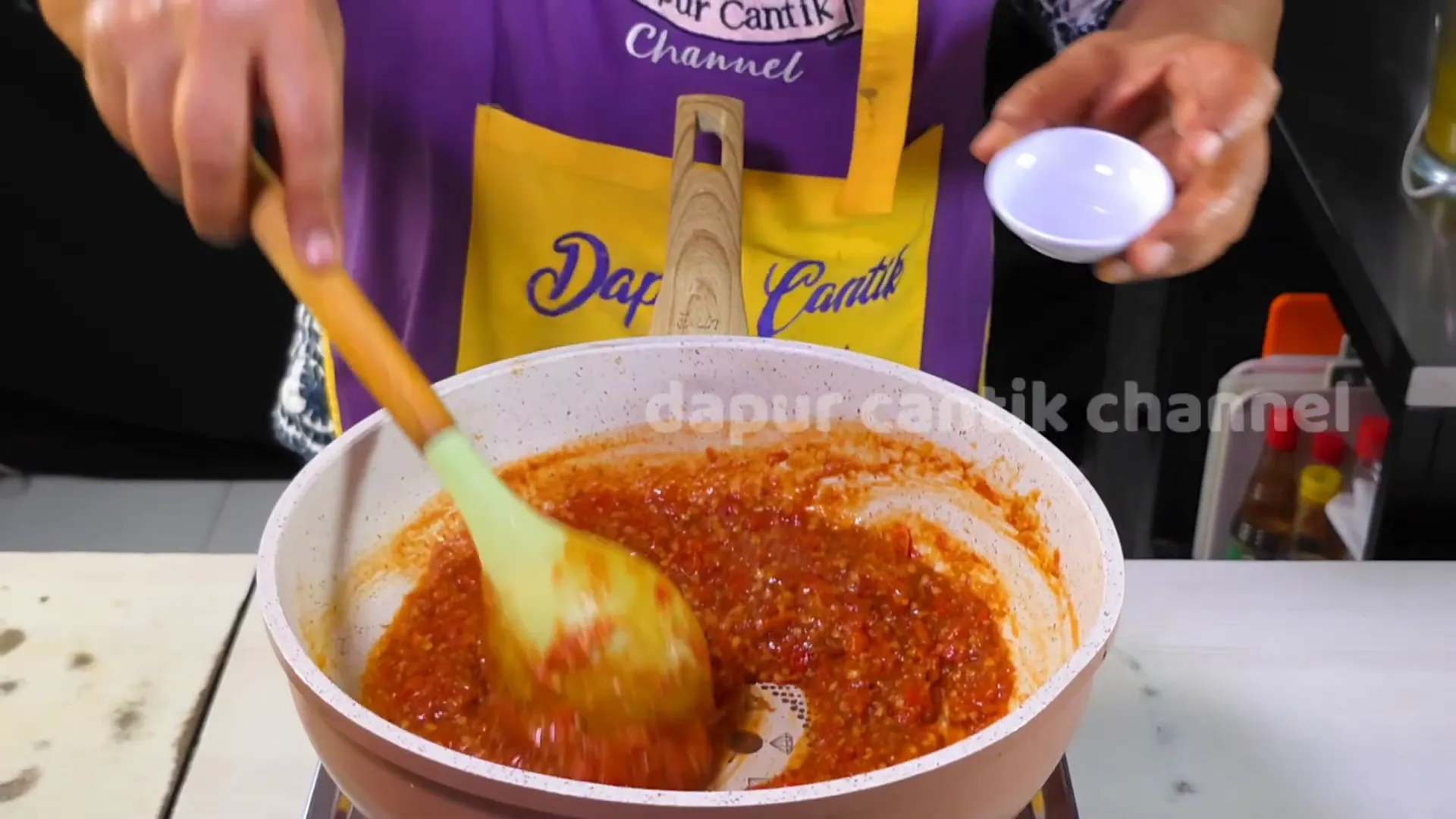 Menambahkan cuka ke dalam sambal sebagai sentuhan terakhir