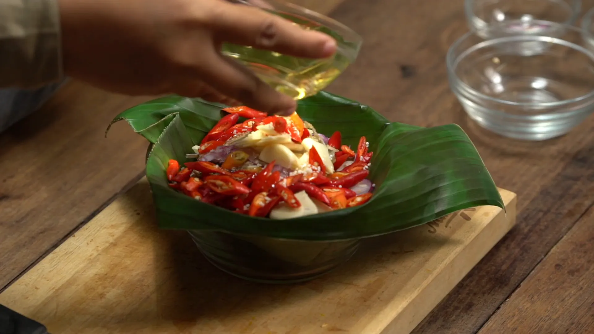 Blenyek dan bumbu siap dikukus dalam wadah dengan alas daun pisang