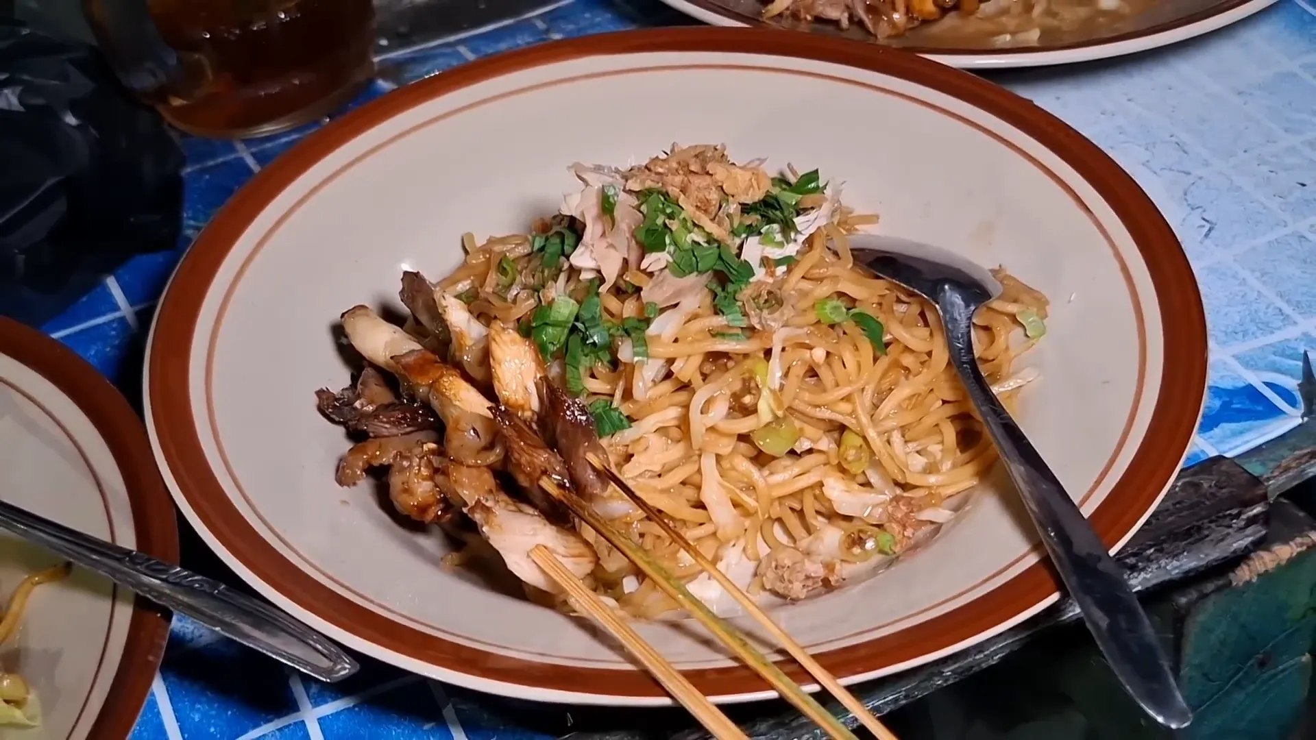 Seporsi mie tek-tek dengan tiga tusuk sate ayam kampung