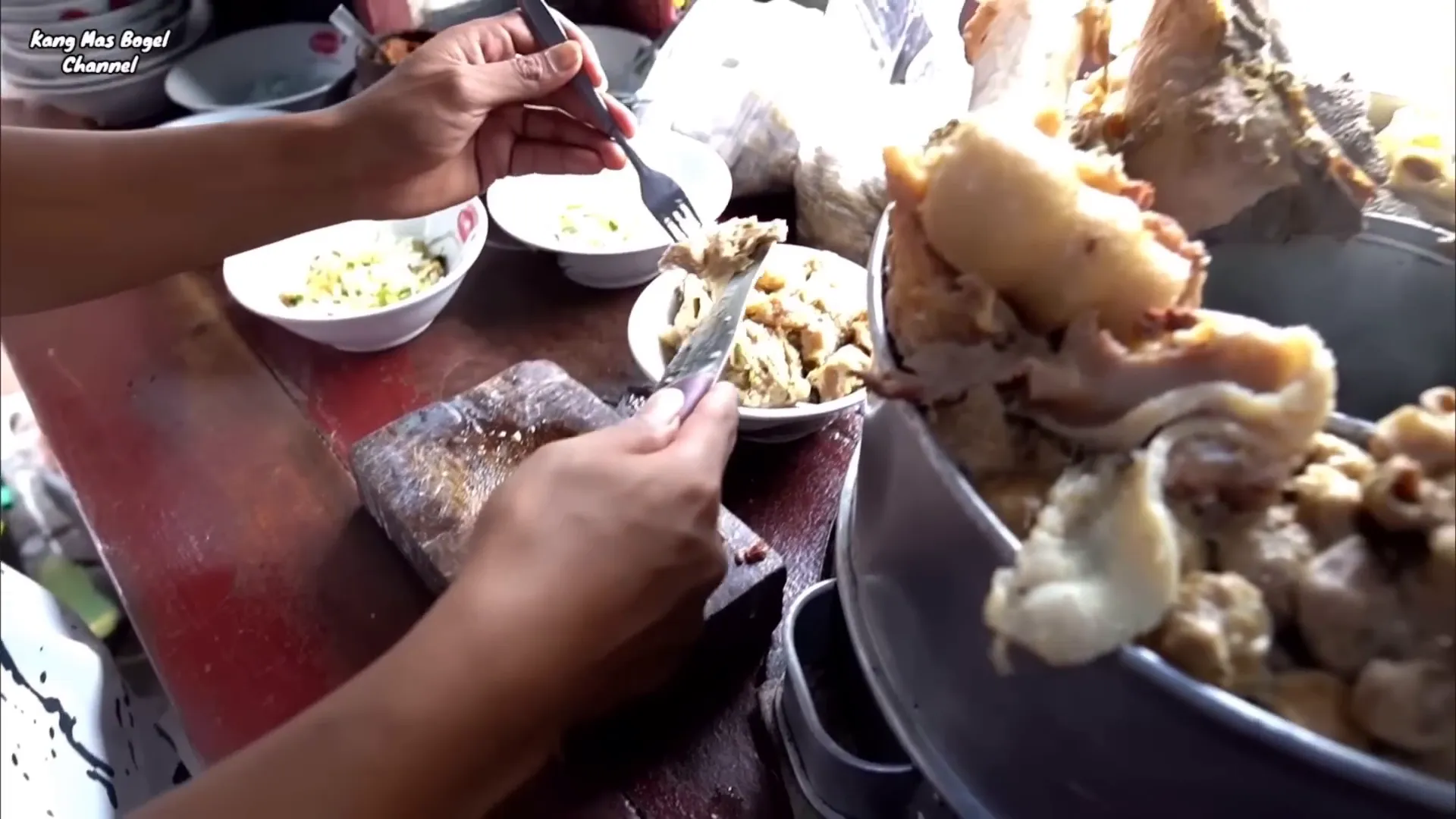 Penjual sedang menyiapkan porsi bakso spesial dengan jeroan lengkap
