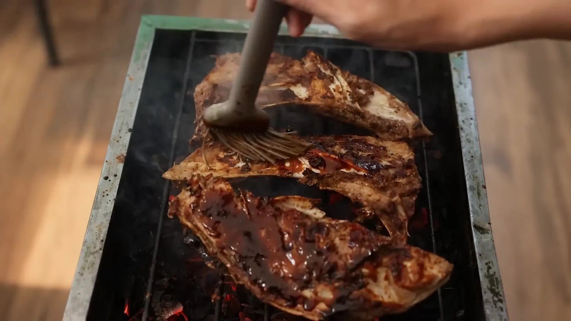 Mengolesi rahang tuna dengan kecap manis dan saus tiram sebelum finishing bakar