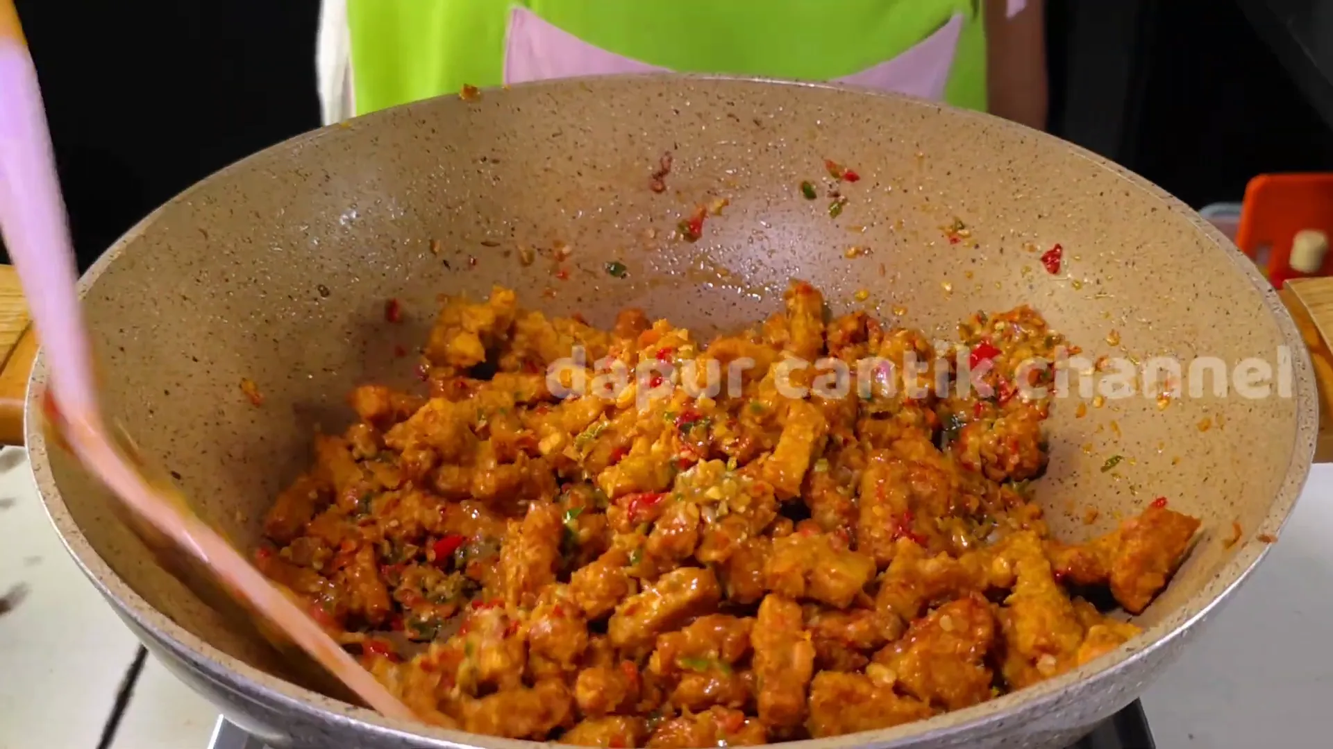 Oseng tempe pedas sedang dimasak dengan bumbu cabai yang melimpah