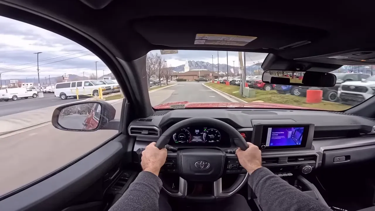 Toyota 4Runner driving POV showing steering wheel, instrument cluster and infotainment