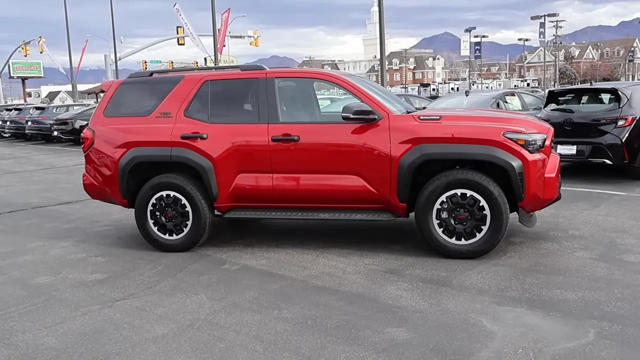 Full side profile of a red 2026 Toyota 4Runner TRD Off‑Road showing fender flares, side step and overall stance.
