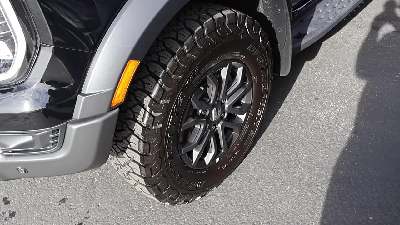 High-resolution view of a truck's aggressive all-terrain tire and wheel showing tread and rim
