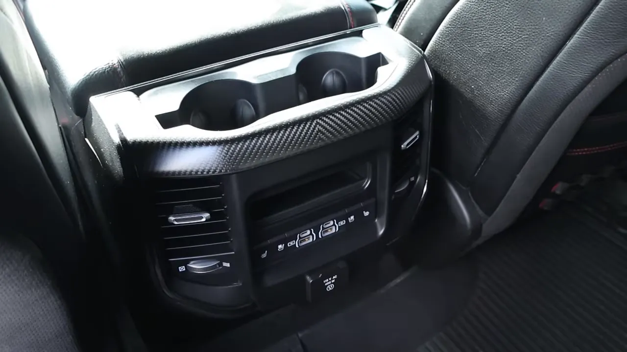 Bright view of rear center console cupholders, ventilation controls, heated-seat buttons and 12V power outlet