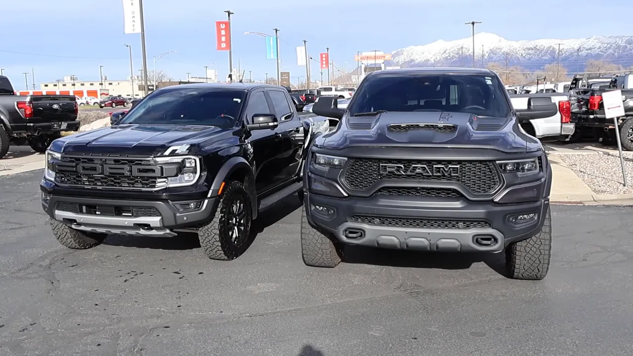Ford Ranger Raptor parked next to a Ram T‑Rex from the front, showing size and stance difference