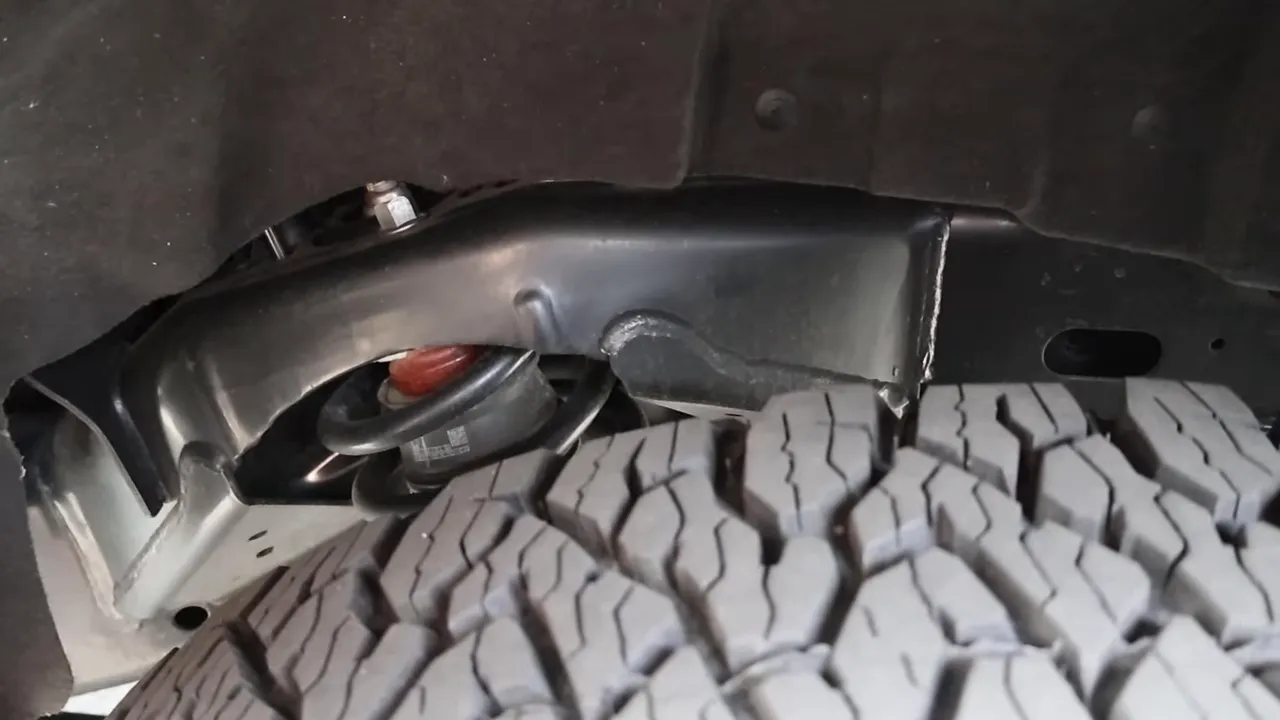 truck coil spring and wheel well close-up with tire