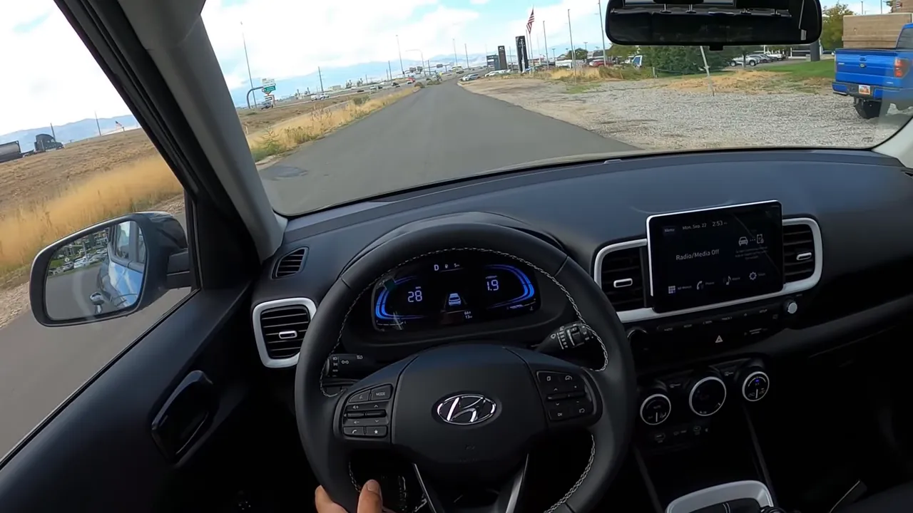 Centered driver view Hyundai Venue cockpit with digital gauges and open road ahead