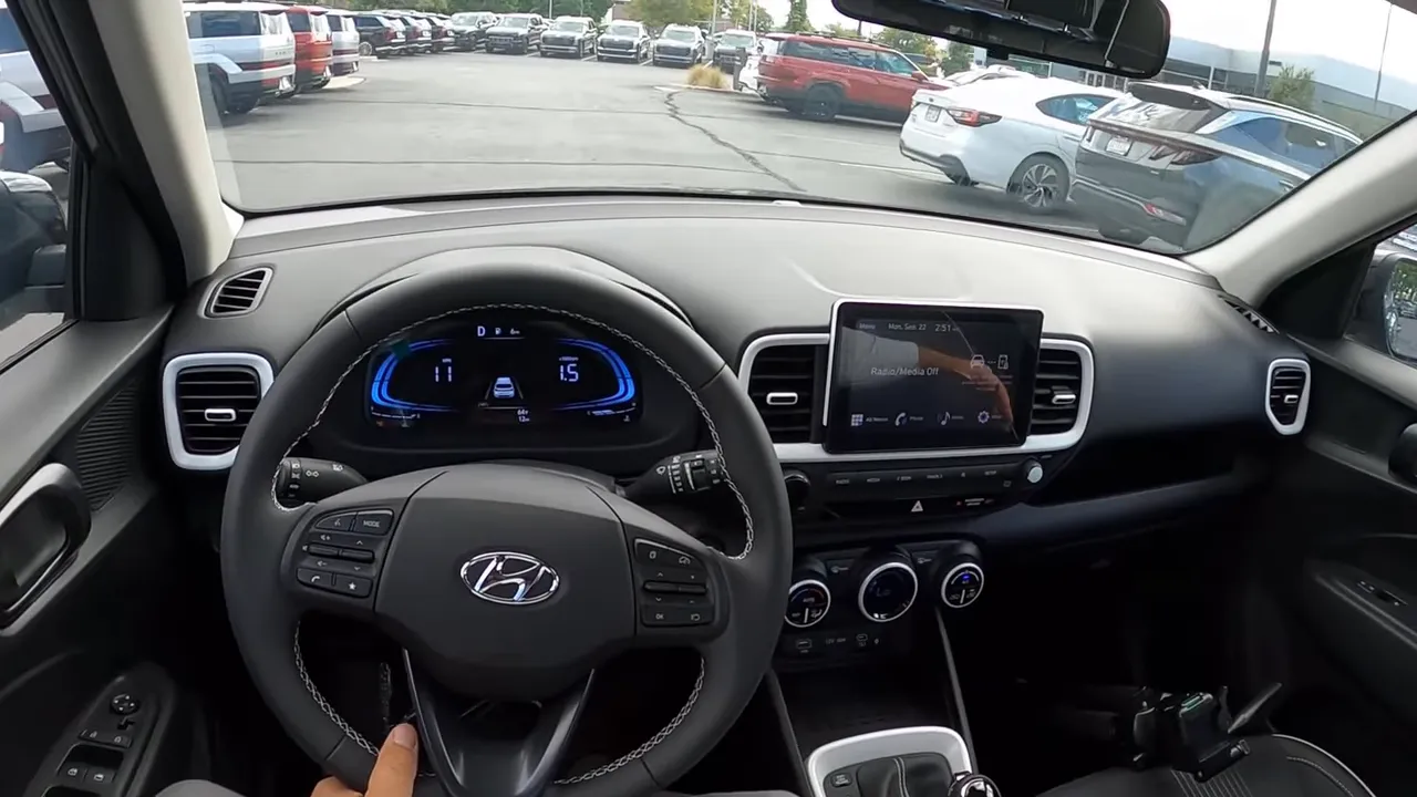Hyundai Venue centered driver point-of-view showing steering wheel, digital instrument cluster and infotainment screen
