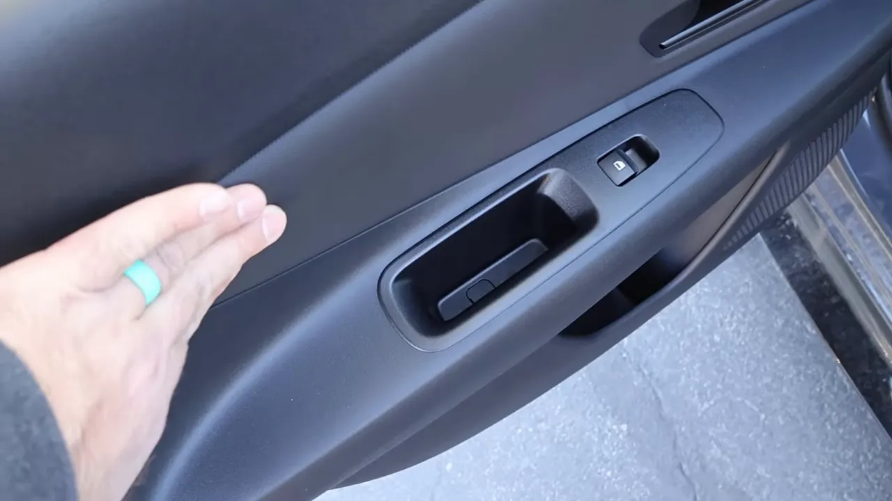 Close-up of Elantra interior door trim with hand demonstrating material and fit