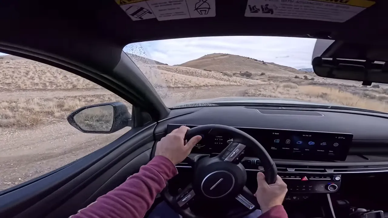 Driver POV showing rocky off-road trail, hood and side mirror with unobstructed ground view