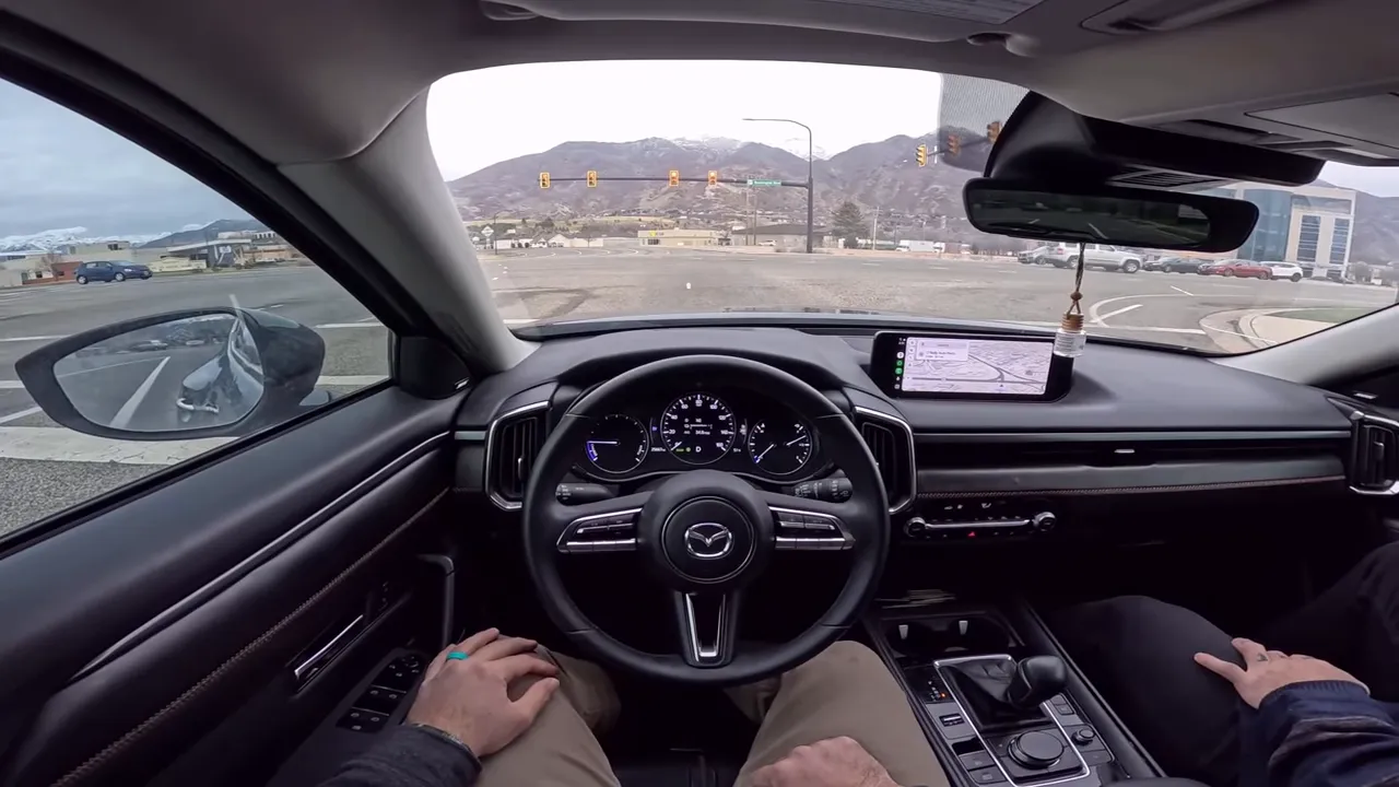Clear centered view of Mazda CX-50 interior showing steering wheel, dashboard, infotainment screen and passenger seat