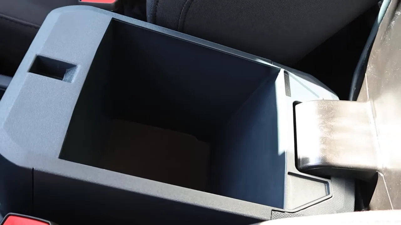 Open center console storage bin in the Ford Maverick XL showing deep storage space