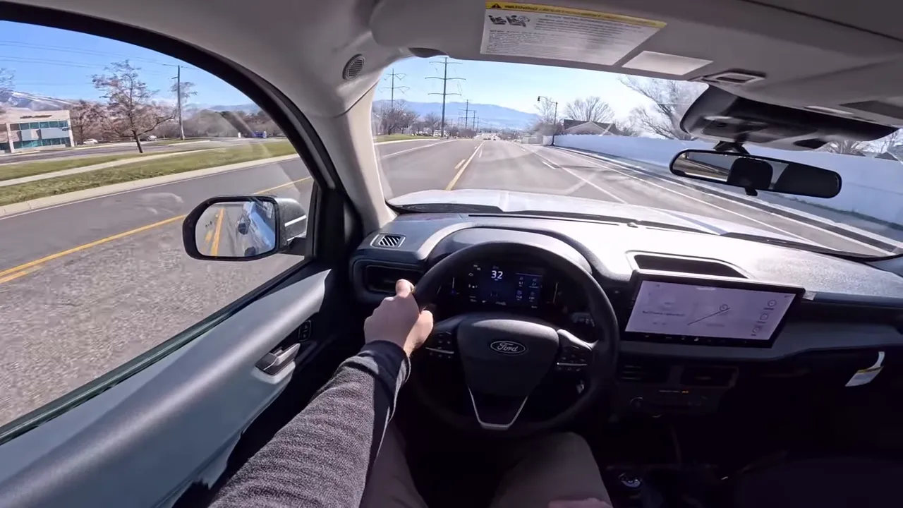 Centered driver view of Ford Maverick showing steering wheel, digital instrument cluster and road ahead