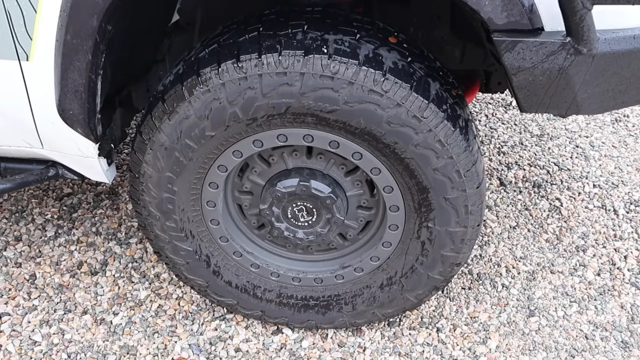 Clear close-up of 18-inch wheel with 35-inch all-terrain tire showing fitment and tread