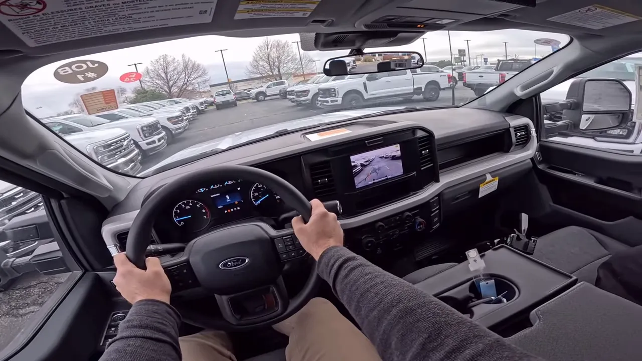 Driver perspective interior shot of 2026 Ford F-250 showing steering wheel, dashboard and road ahead