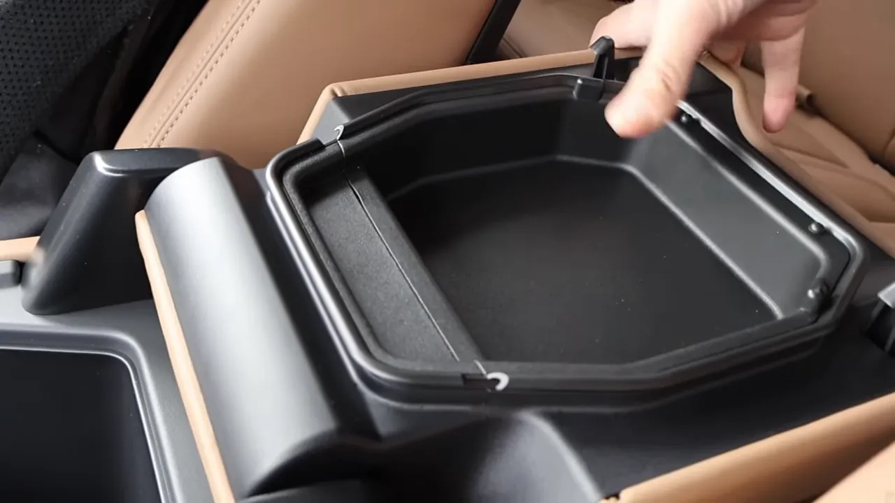 Removable center-console storage insert being lifted from Land Rover Defender