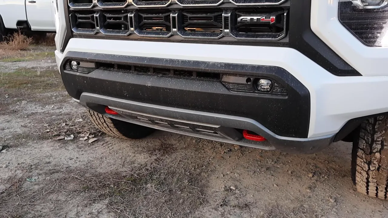 Close view of 2026 GMC Canyon AT4 lower bumper showing skid plate and red recovery hooks