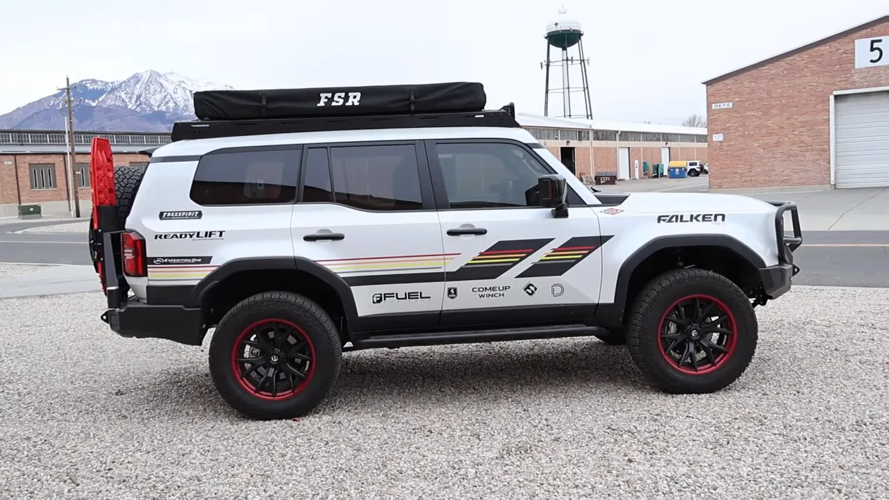 Side profile of Expedition One Land Cruiser showing 285/65R20 tires on 20-inch wheels, ReadyLift lift, step sliders and roof rack