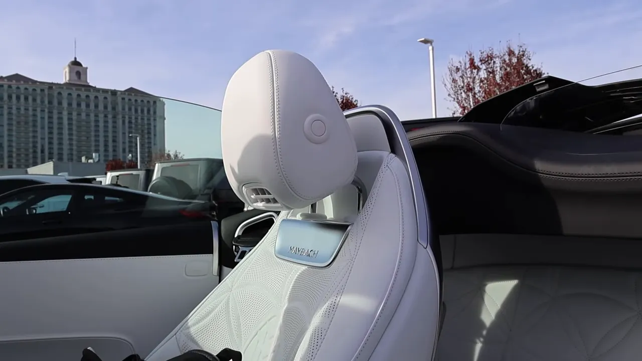 Front seat and headrest of Maybach SL680 with the convertible roof stowed, showing Maybach badge on the seat
