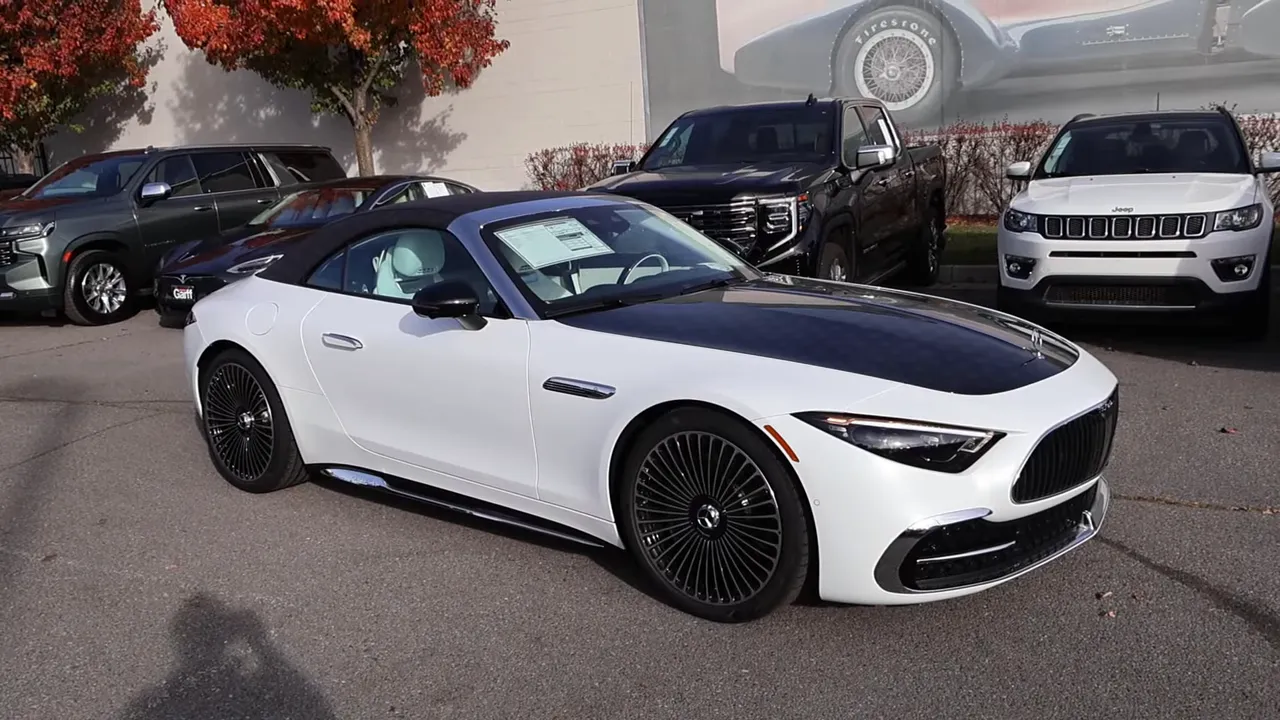 Front three-quarter view of a white Maybach SL680 convertible with black soft top showing overall profile and top finish