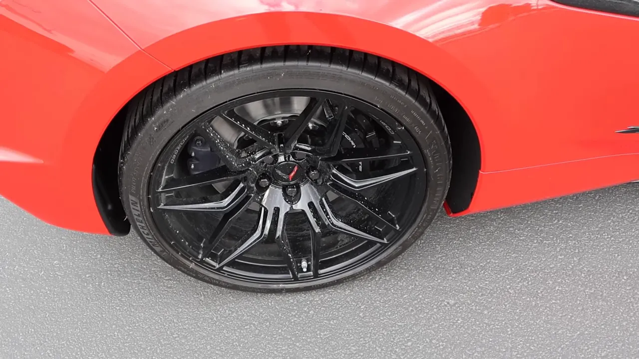 Full close-up of Corvette wheel, Michelin tire and brake caliper on red fender