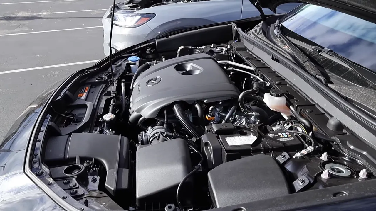 Mazda CX‑30 engine bay with Mazda-branded engine cover, battery and intake components visible