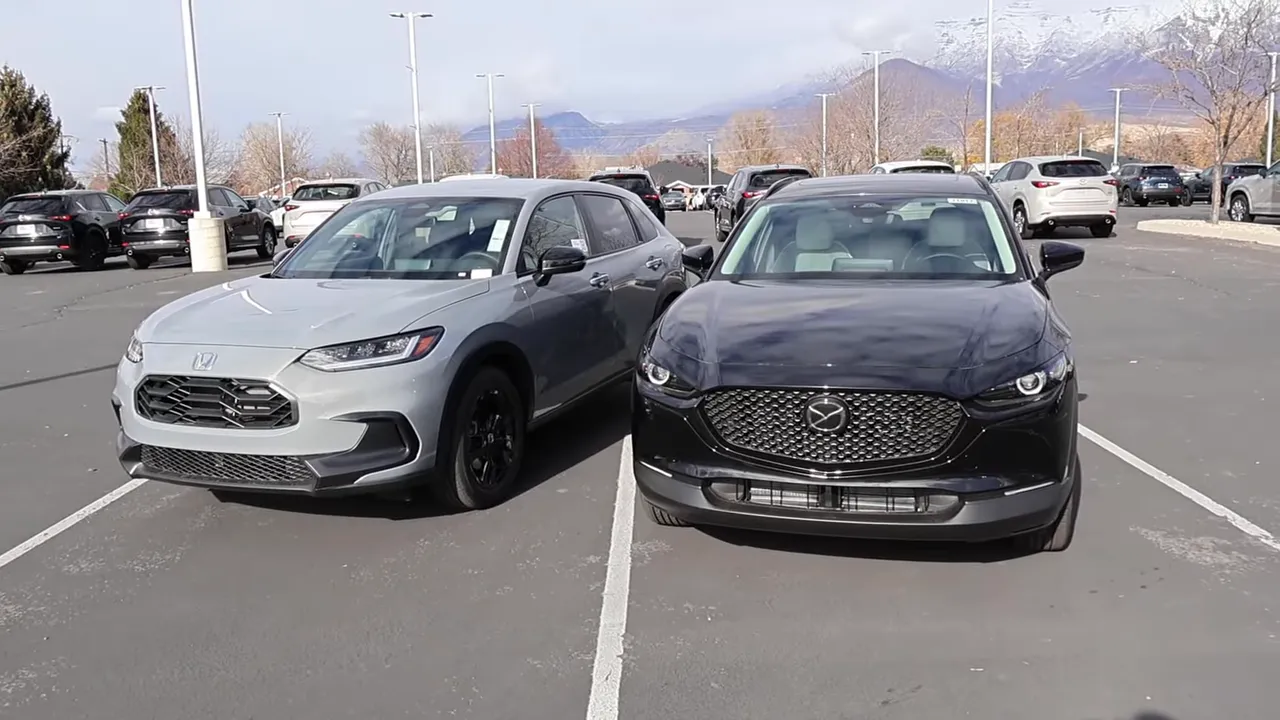 Mazda CX-30 (right) and Honda HR-V (left) parked side-by-side showing their front profiles and styling differences.