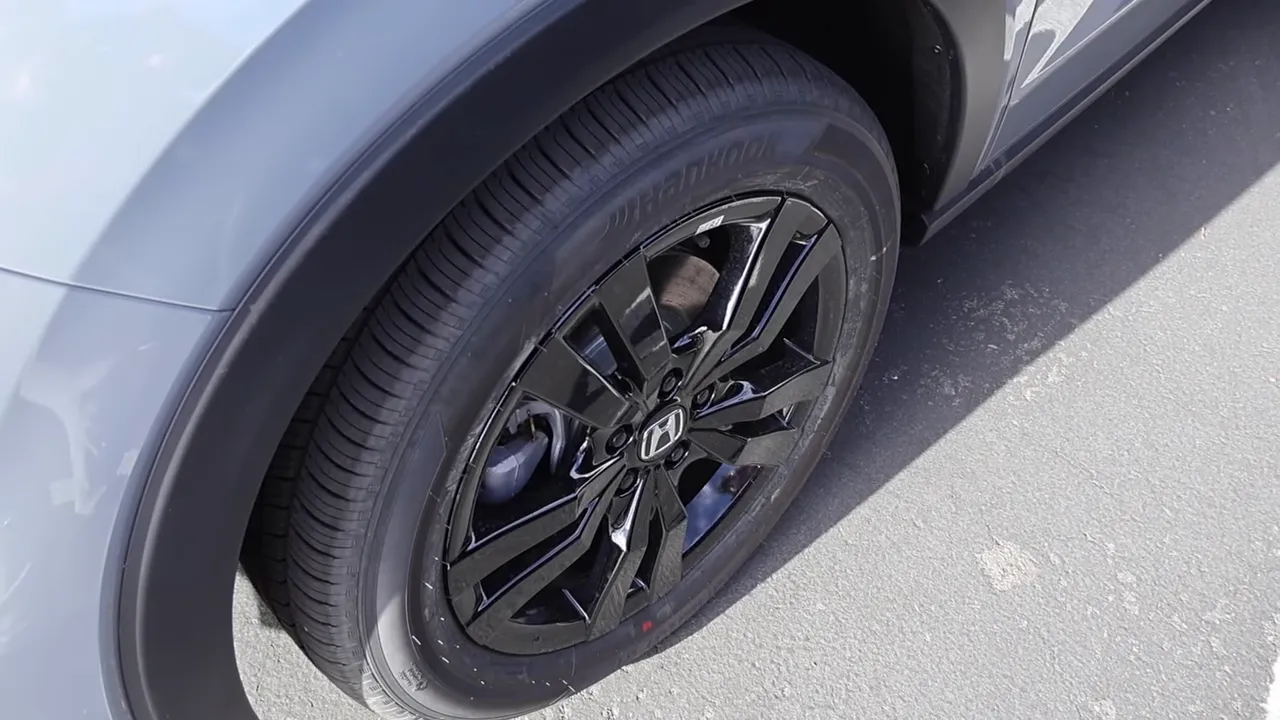 Close-up of a Honda black alloy wheel and tire showing tread and sidewall.