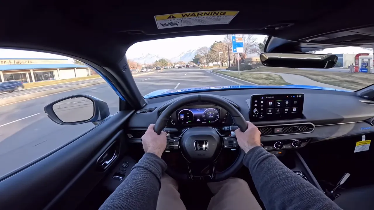 Front-facing cockpit view of the 2026 Honda Prelude showing steering wheel with paddles, digital instrument cluster and driver's hands