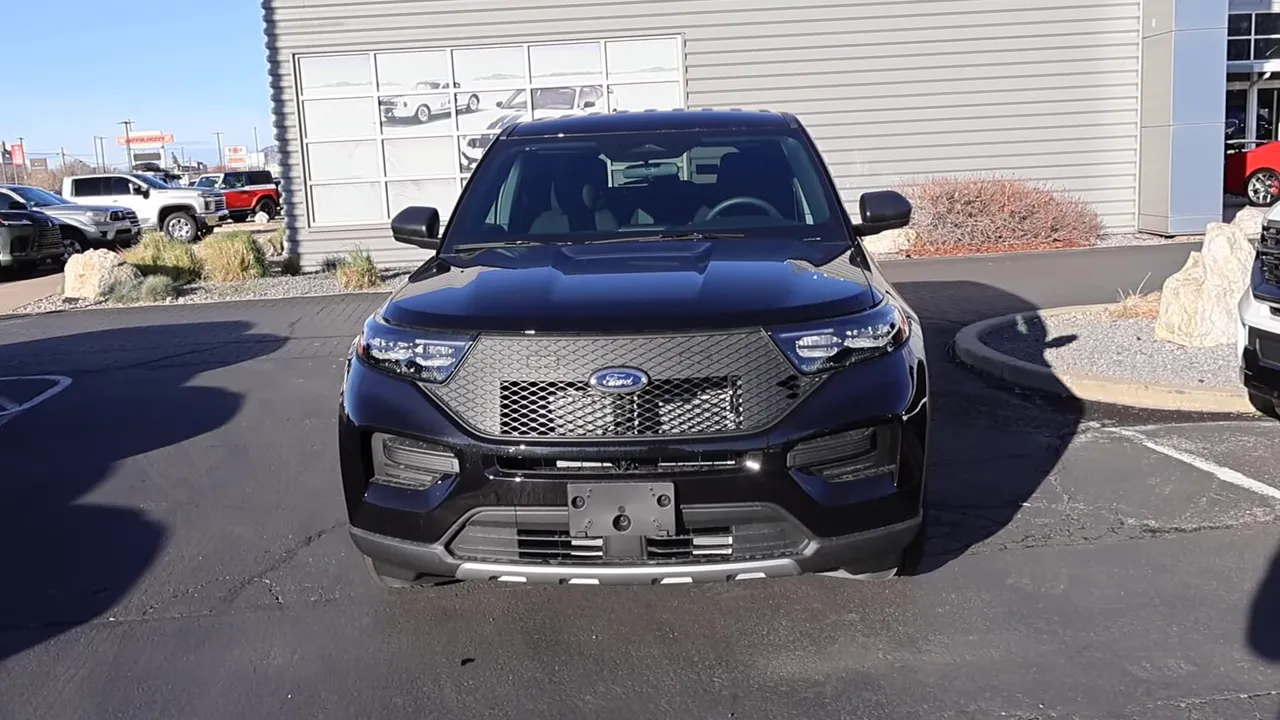 Front view of a 2026 Ford Explorer Police Interceptor parked at a dealership, showing grille, hood and lot surroundings