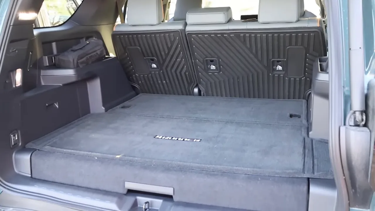 Wide view into the 4Runner Trailhunter cargo bay showing folded rear seats, flat load floor and side storage compartments