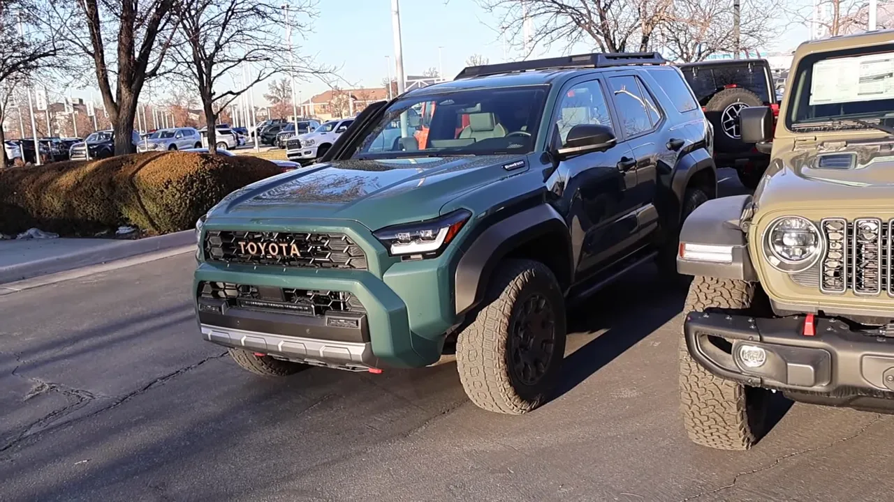 Front three-quarter view of 2026 Toyota 4Runner Trailhunter parked next to a Jeep Wrangler Rubicon highlighting bumper and lights