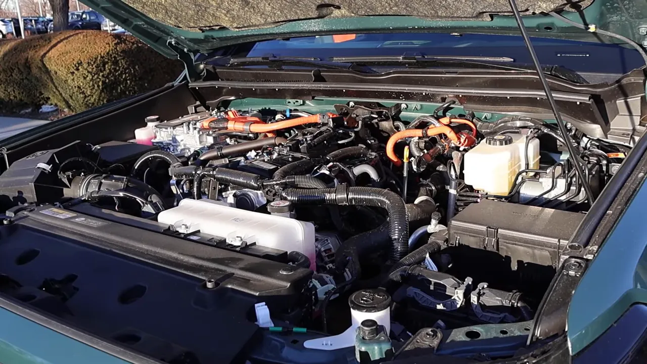 Under-hood view of a 2026 SUV with visible orange hybrid high-voltage cables, fluid reservoirs and engine components