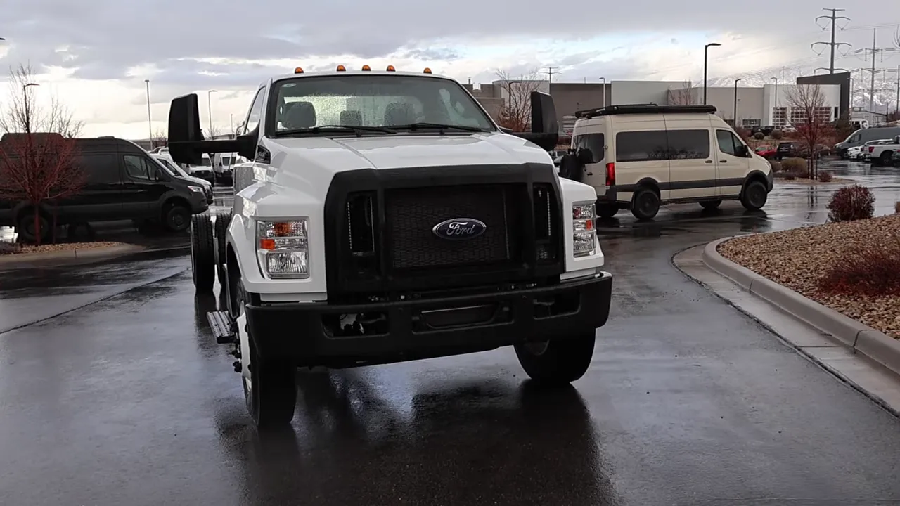 Three-quarter front view of a Ford F-650 showing front and rear wheels on wet pavement