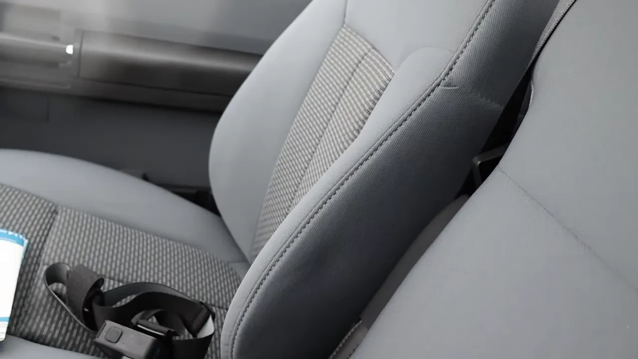 Front passenger cloth seats and seatbelt in the Ford F-650 interior showing durable materials and stitching.