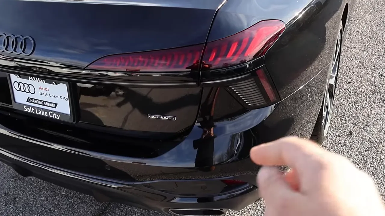 Hand pointing at 2026 Audi A6 taillight taper and lower bumper detail