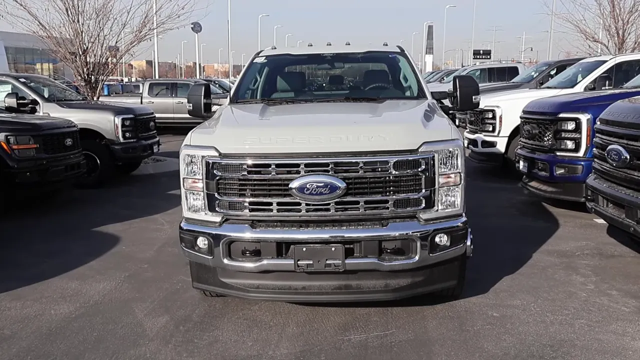 Front view of 2026 Ford F-350 XLT dually highlighting chrome bumper and halogen headlights in a dealership lot