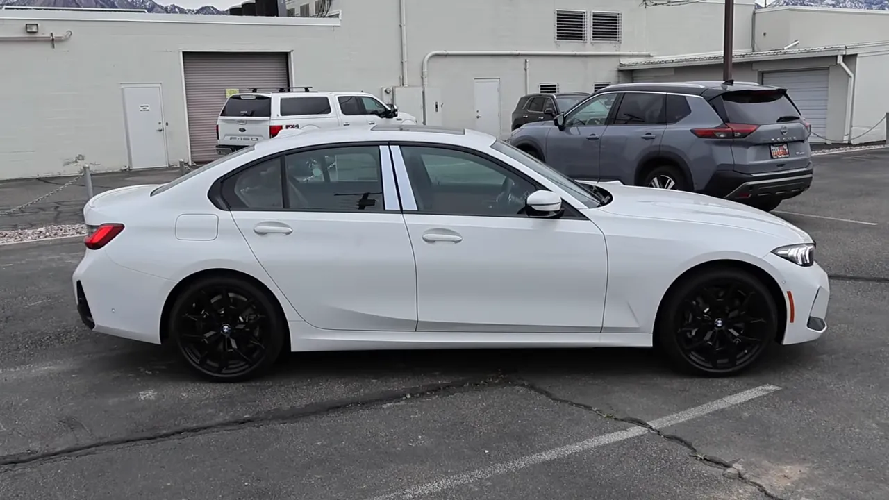 Full side view of white 2026 BMW 330i with black wheels in a parking lot