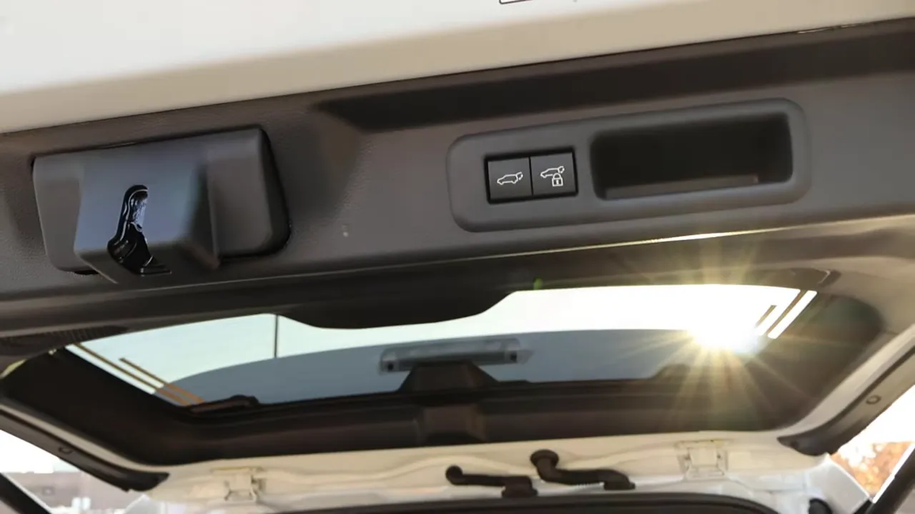 Toyota Sequoia rear hatch underside showing power hatch buttons and pop-open rear window with sun glare