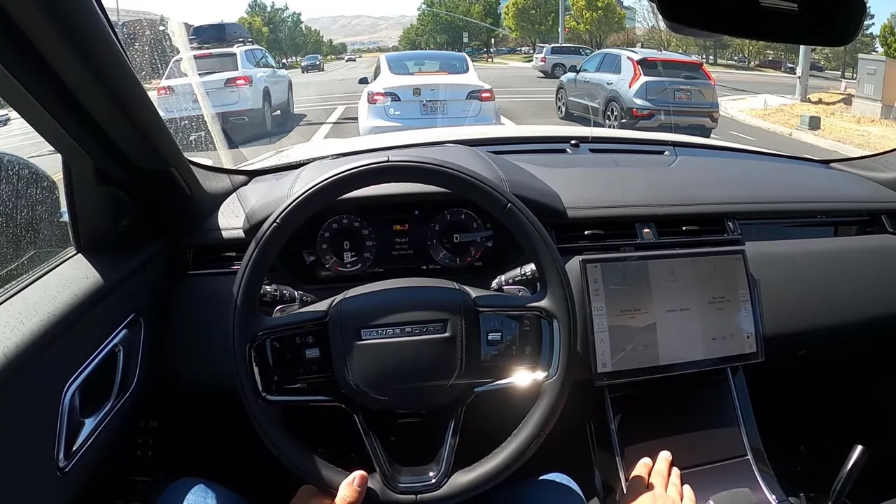 Driver POV Range Rover Velar steering wheel and instrument cluster with central touchscreen