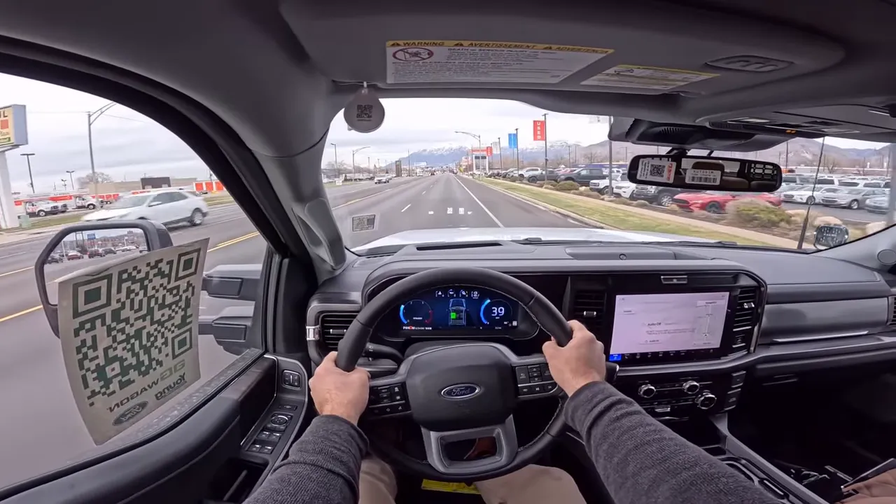 Straight-on interior shot of AG Wagon showing steering wheel at 9-and-3, digital instrument cluster reading 39 mph and clear view of road