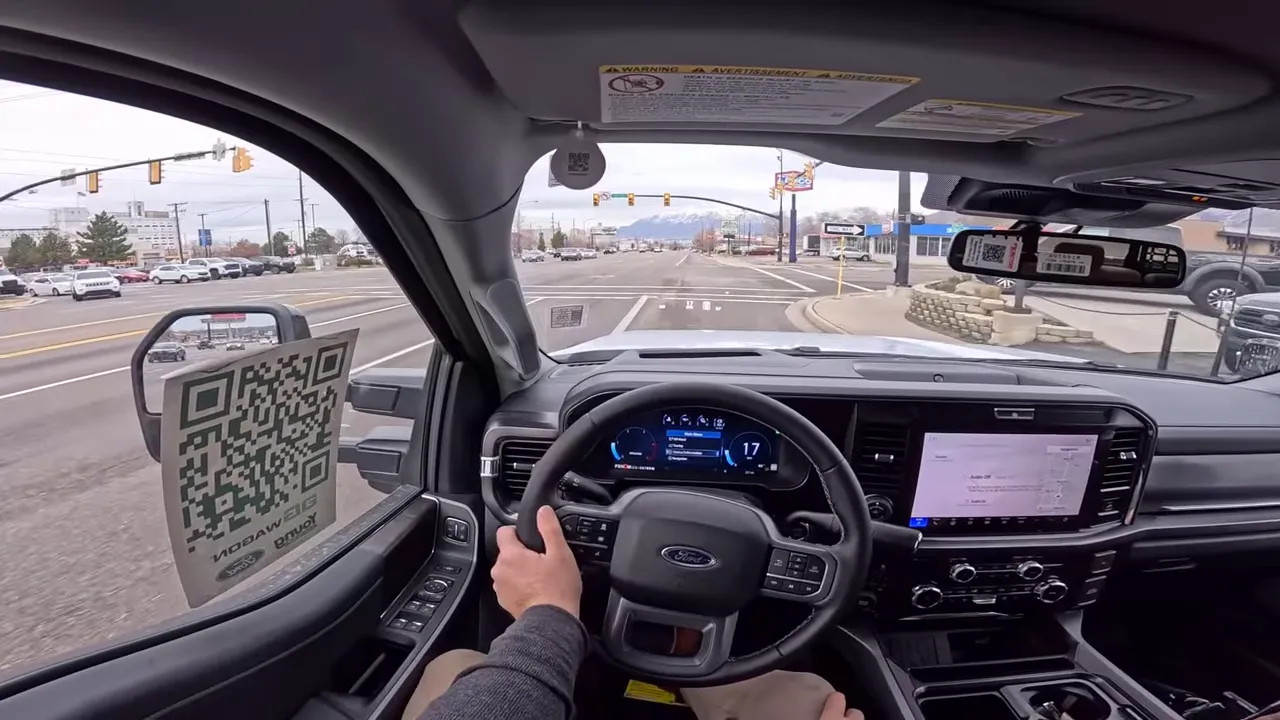 Driver POV interior shot of the AG Wagon with steering wheel, digital instrument cluster reading 17 mph and road ahead
