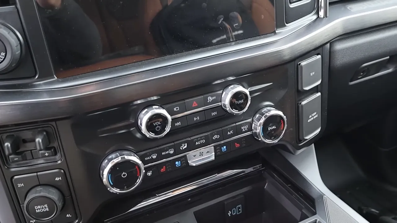 Truck center stack showing climate knobs, media controls, drive mode dial and storage bin