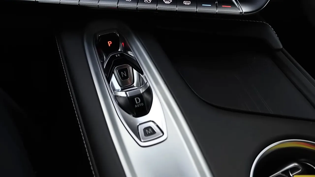 Center console showing Corvette grab‑handle shifter with P/R/N/D and M drive mode button