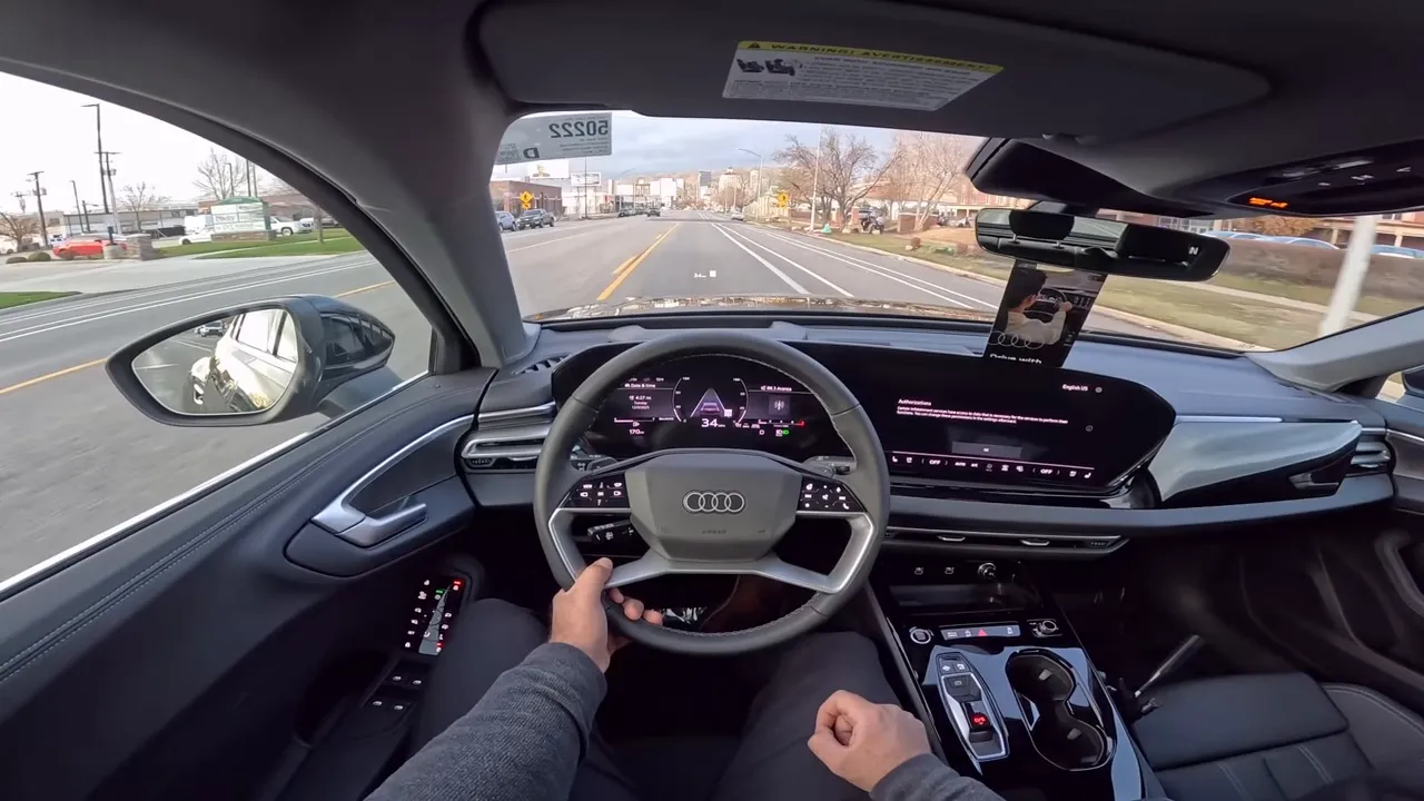 Front interior view of 2026 Audi A5 showing steering wheel, digital gauge cluster and large center touchscreen