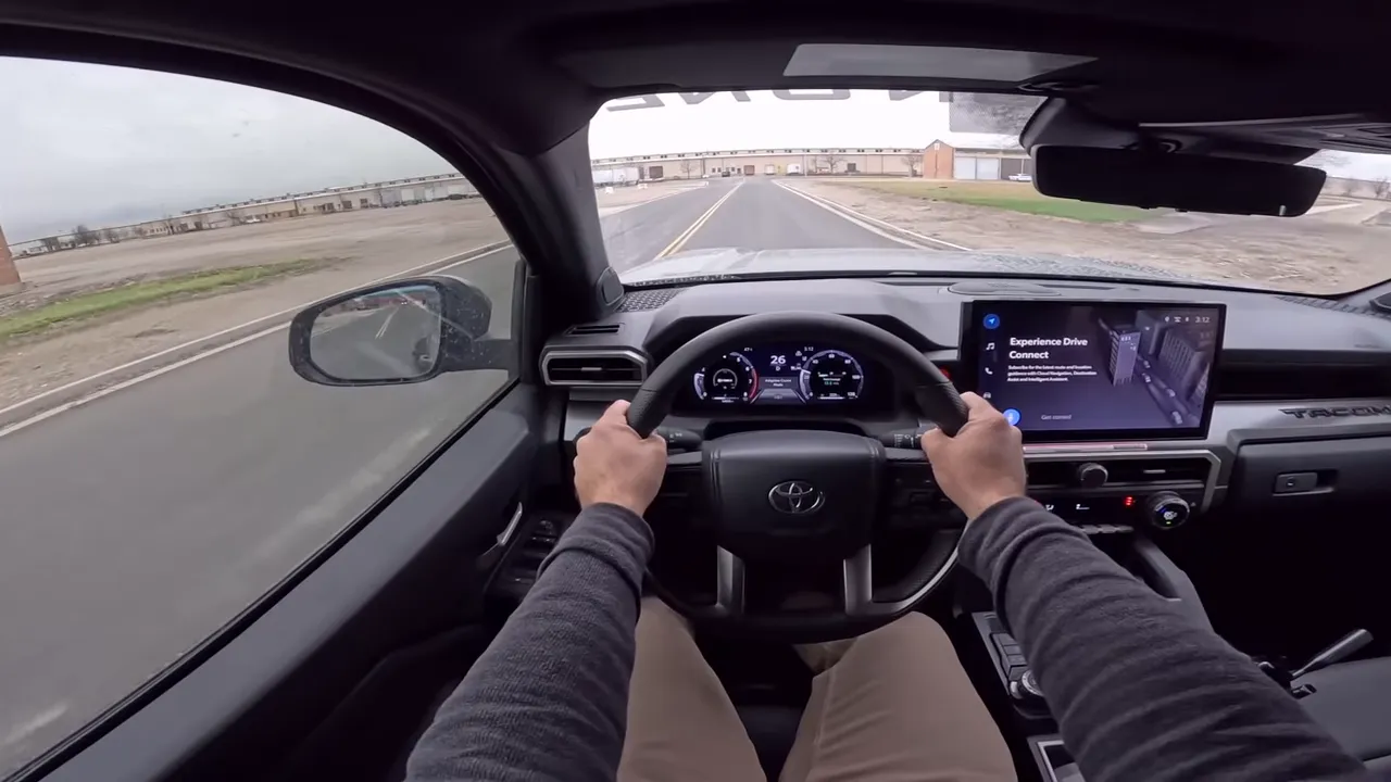 centered driver view of Tacoma steering wheel instrument cluster and road ahead